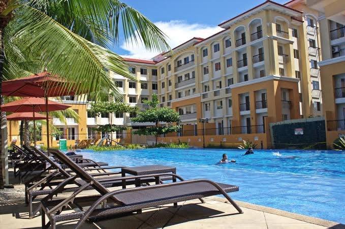 Resort pool with lounge chairs and red umbrellas